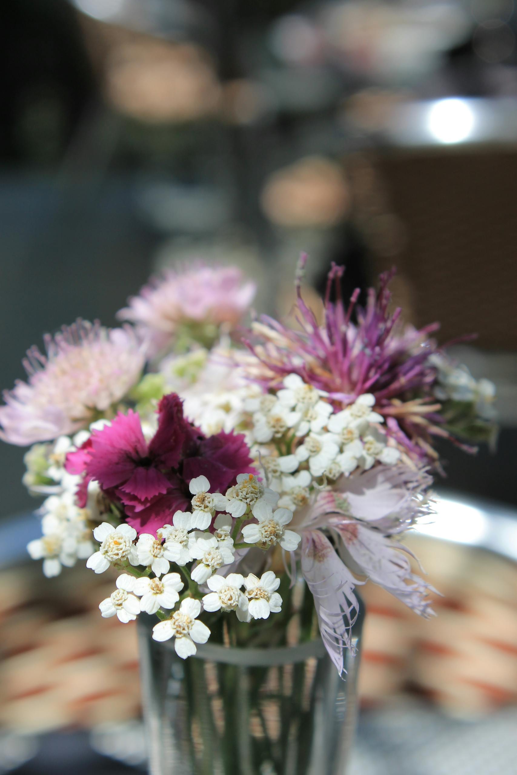 Vibrant bouquet of mixed flowers in a vase on a sunny day.